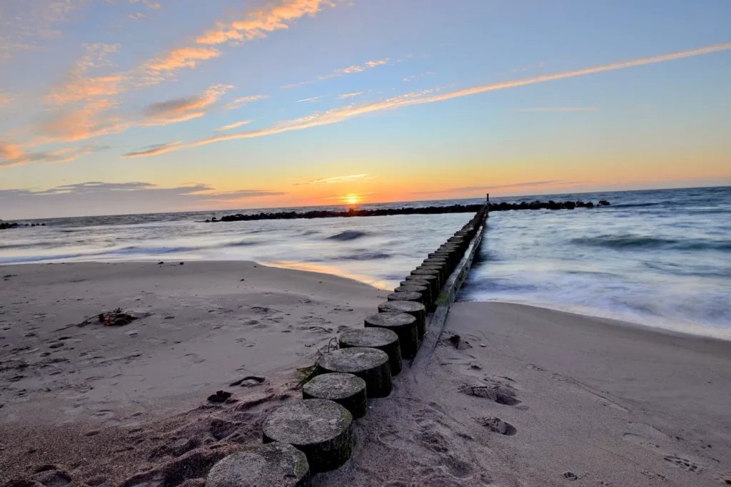 Plaża w Darłówku o zachodzie słońca, drewniana ostroga wchodząca w morze