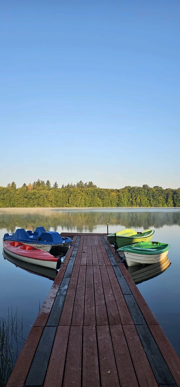 Pomost z kajakiem, rowerkiem wodnym i łódkami o poranku